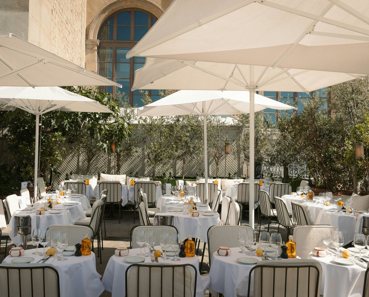 Terraza de restaurante con las mesas vestidas con mantelería blanca